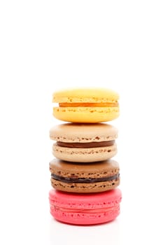 Four delicious mouthwatering baked macaroon biscuits of various flavours standing tall in a tower stack.  Isolated on white background.  Space for text.
