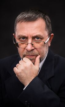 Portrait of handsome senior man with glasses prop up the head with his hand