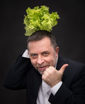 Healthy food. Man holding  lettuce and shows the symbol OK