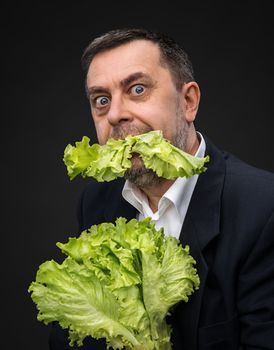 Healthy food. Man holding and eating lettuce