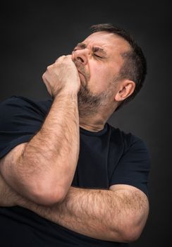 Headache. Portrait of an elderly man with face closed by hand