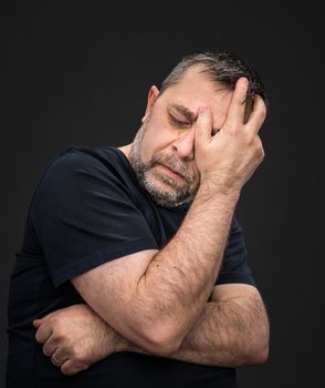 Headache. Portrait of an elderly man with face closed by hand