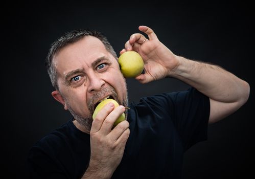 Portrait of a middle-aged man with a green apples