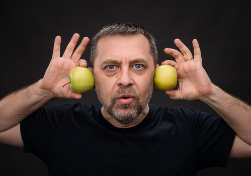 Portrait of a middle-aged man with a green apples