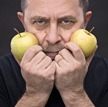 Portrait of a middle-aged man with a green apples