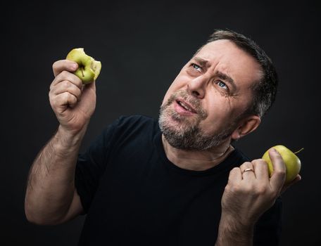 Portrait of a middle-aged man with a green apples