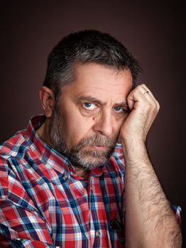 Portrait of a serious middle-aged man on a dark background