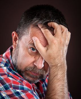 Portrait of a thoughtful elderly man with hand near the face