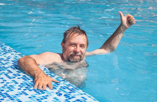 Healthy lifestyle. Happy middle-aged man in a swimming pool