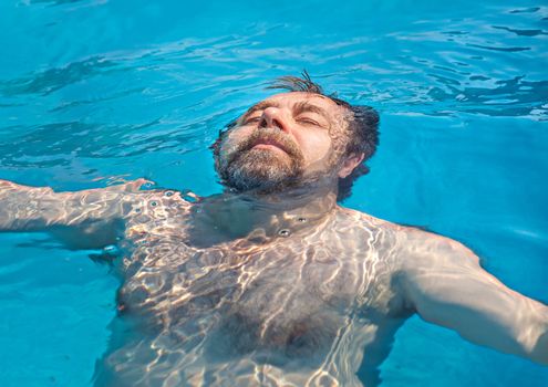 Healthy lifestyle. Middle-aged man in a swimming pool