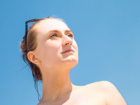 Portrait of an young beautiful woman sunbathing against blue sky