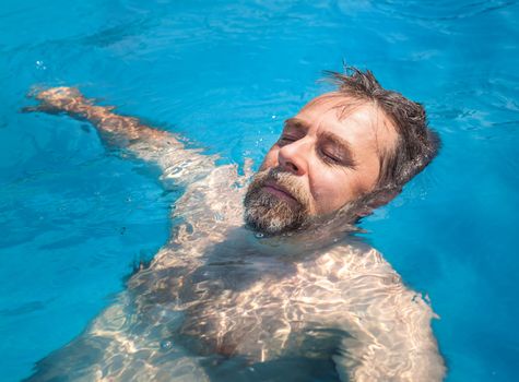 Healthy lifestyle. Middle-aged man in a swimming pool