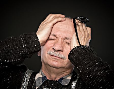  Depression. Elderly man suffering from a headache