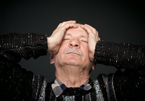  Depression. Elderly man suffering from a headache