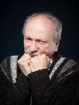 Portrait of senior man prop up the head with his fists