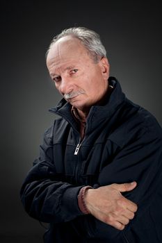 Portrait of a wise old man in a dark jacket