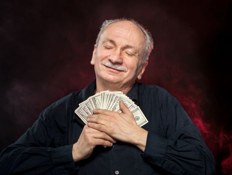 Lucky, old man holding with pleasure group of dollar bills