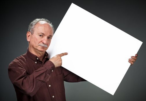 An elderly man holding a blank billboard