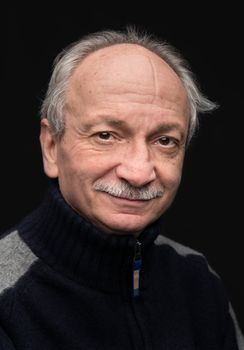 Portrait of a smiling elderly man on dark background