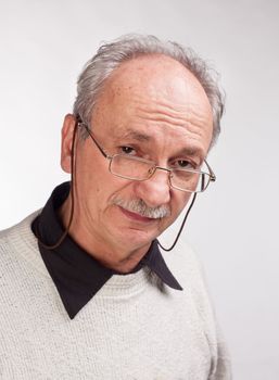 Portrait of a happy mature man with glasses and a white sweater
