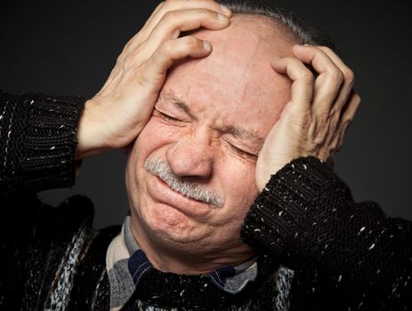  Depression. Elderly man suffering from a headache