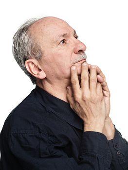 Elderly man with hands near his face  looking up thinking
