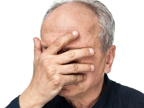 Pain. Elderly man covers his face with hand