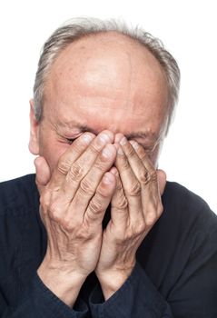 Portrait of an elderly man with face closed by hand. Focus on hands