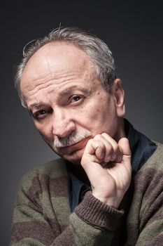 Portrait of an elderly man looks skeptically