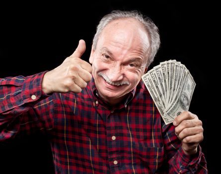 Happy elderly man showing fan of money and sign OK with fingers