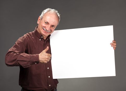 An elderly man holding a blank billboard