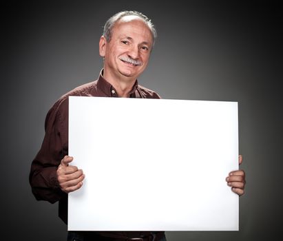 An elderly man holding a blank billboard