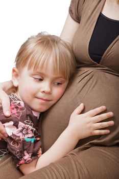 Little girl embracing pregnant mother on white background