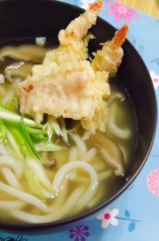 close up  udon noodles with shrimp tempura in black bowl , Japanese food