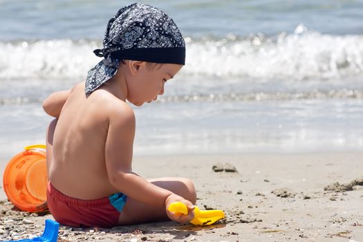 Boy playing with toys on beach