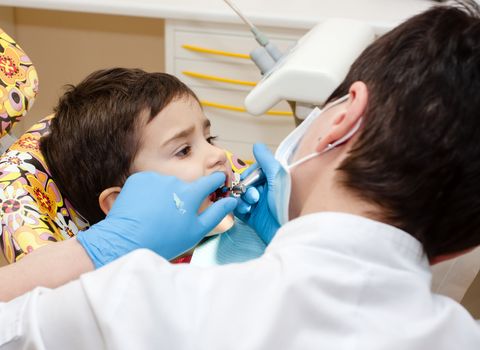 Little boy healing his teeth in dentist's office