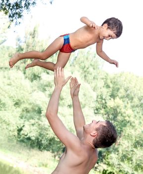 Father throwing his son in the air and catching him