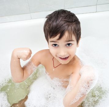 Boy washing in the bathroom and shows muscles