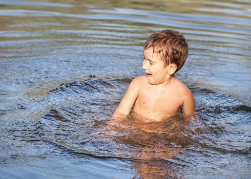 little funny boy playing in water