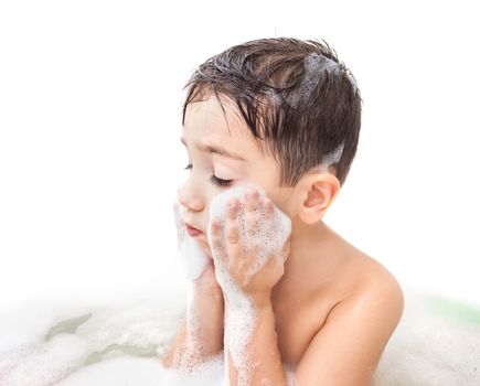 Little boy washing face in the bathroom