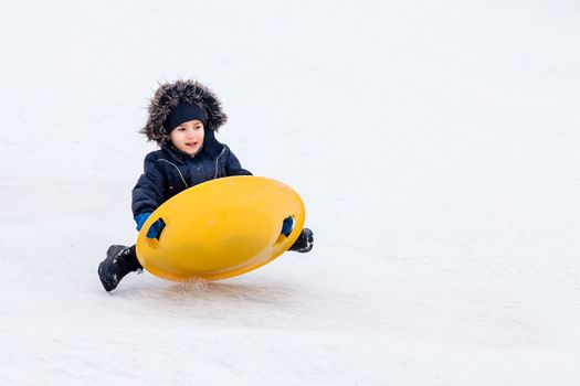 Boy on sleigh. Sledding at winter time