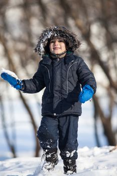 Cute boy walk in the winter park in sunny day