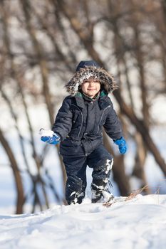 Cute boy walk in the winter park in sunny day