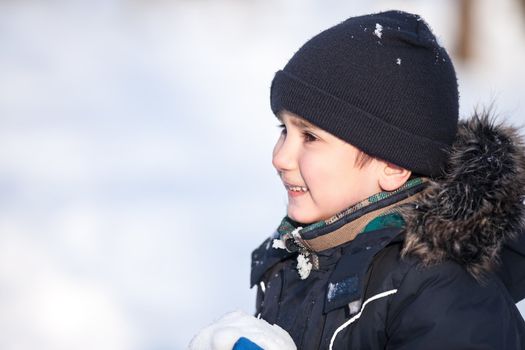 Winter fun. Cute boy playing with snow