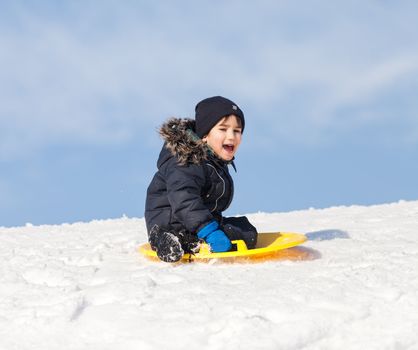 Boy on sleigh. Sledding at winter time