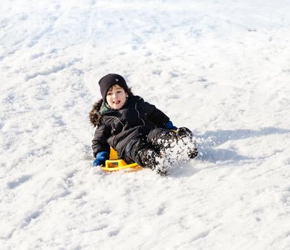 Boy on sleigh. Sledding at winter time