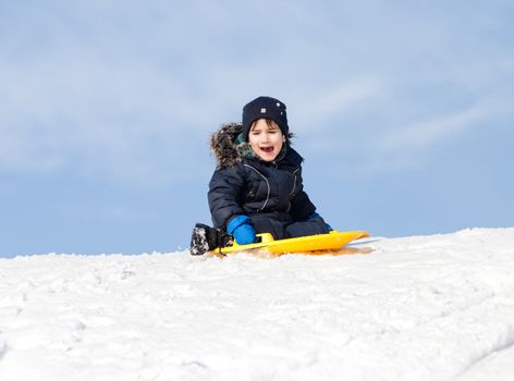 Boy on sleigh. Sledding at winter time