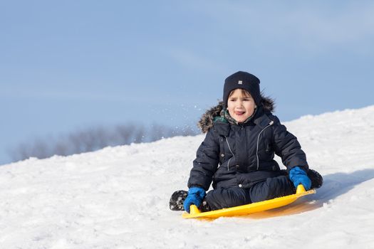 Boy on sleigh. Sledding at winter time