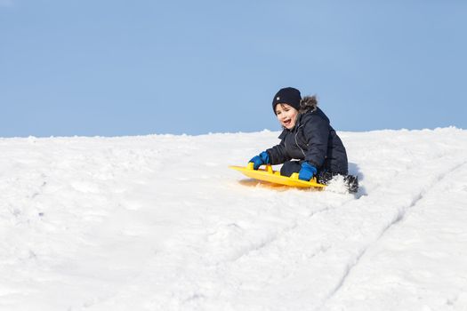 Boy on sleigh. Sledding at winter time