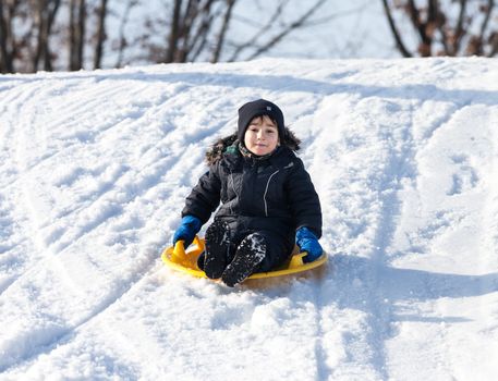 Boy on sleigh. Sledding at winter time